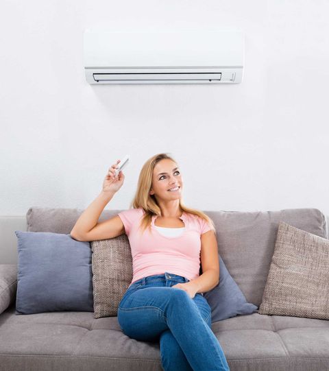 Woman Sitting on Couch Below Air Conditioner Woman Sitting on Couch Below Air Conditioner