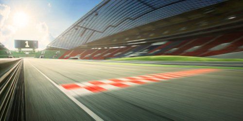 A race car is driving down a race track with a checkered finish line.