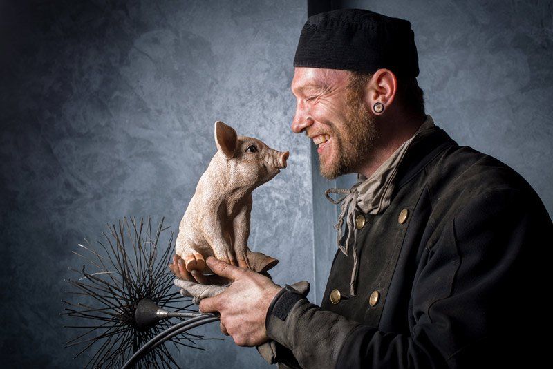 man holding a small pig