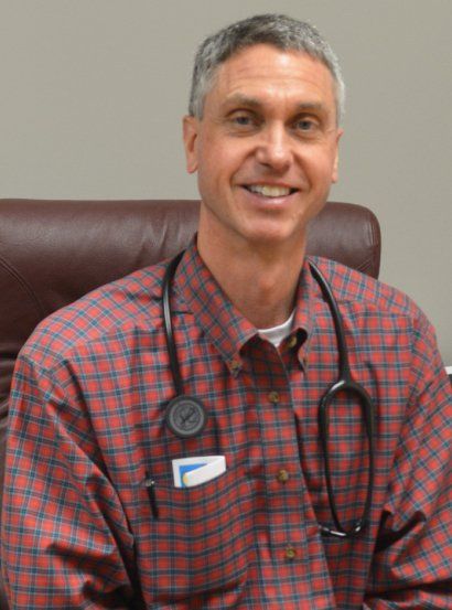 A man wearing a plaid shirt and a stethoscope around his neck