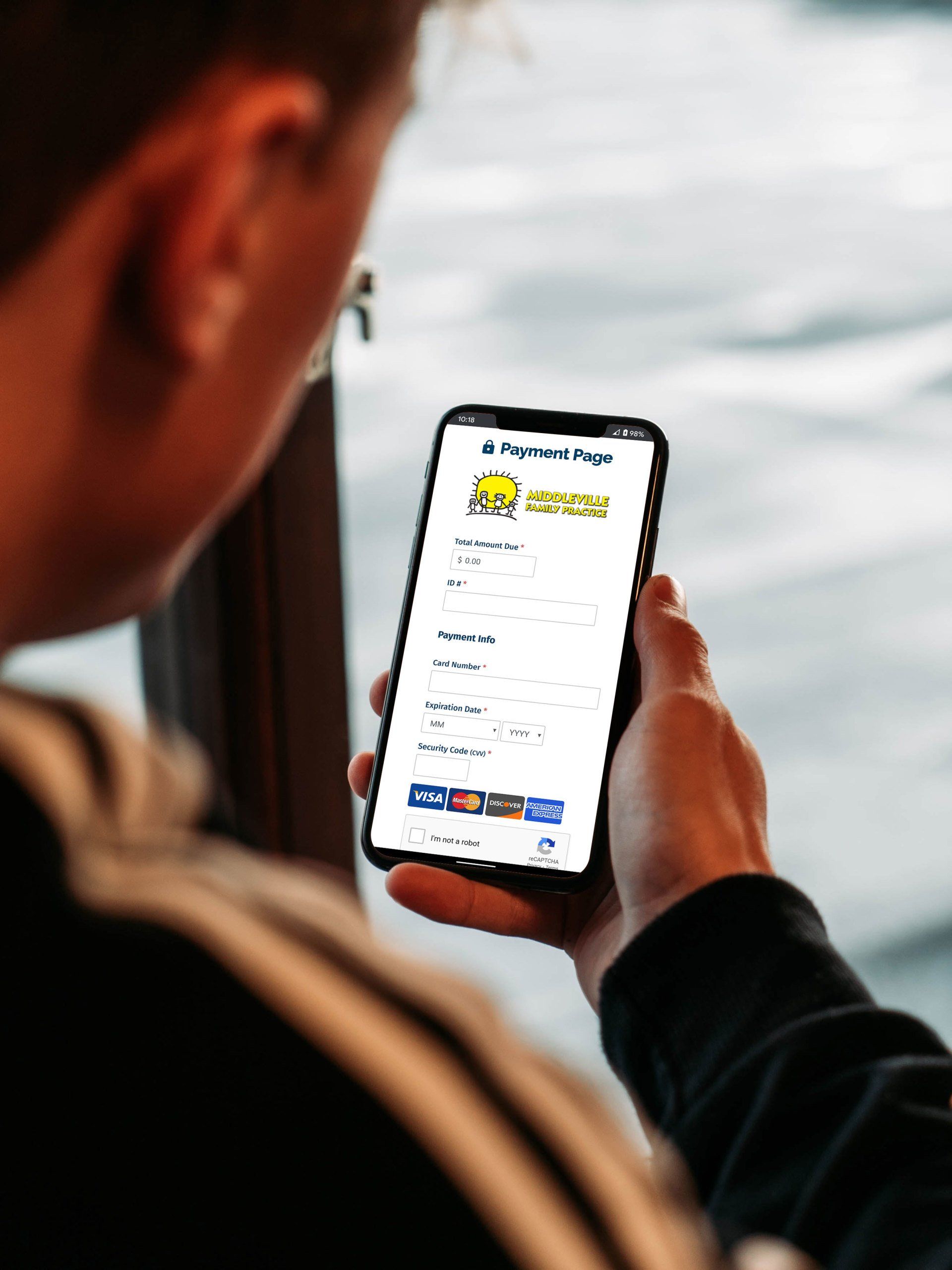 A man is holding a cell phone in his hand and looking at the screen.