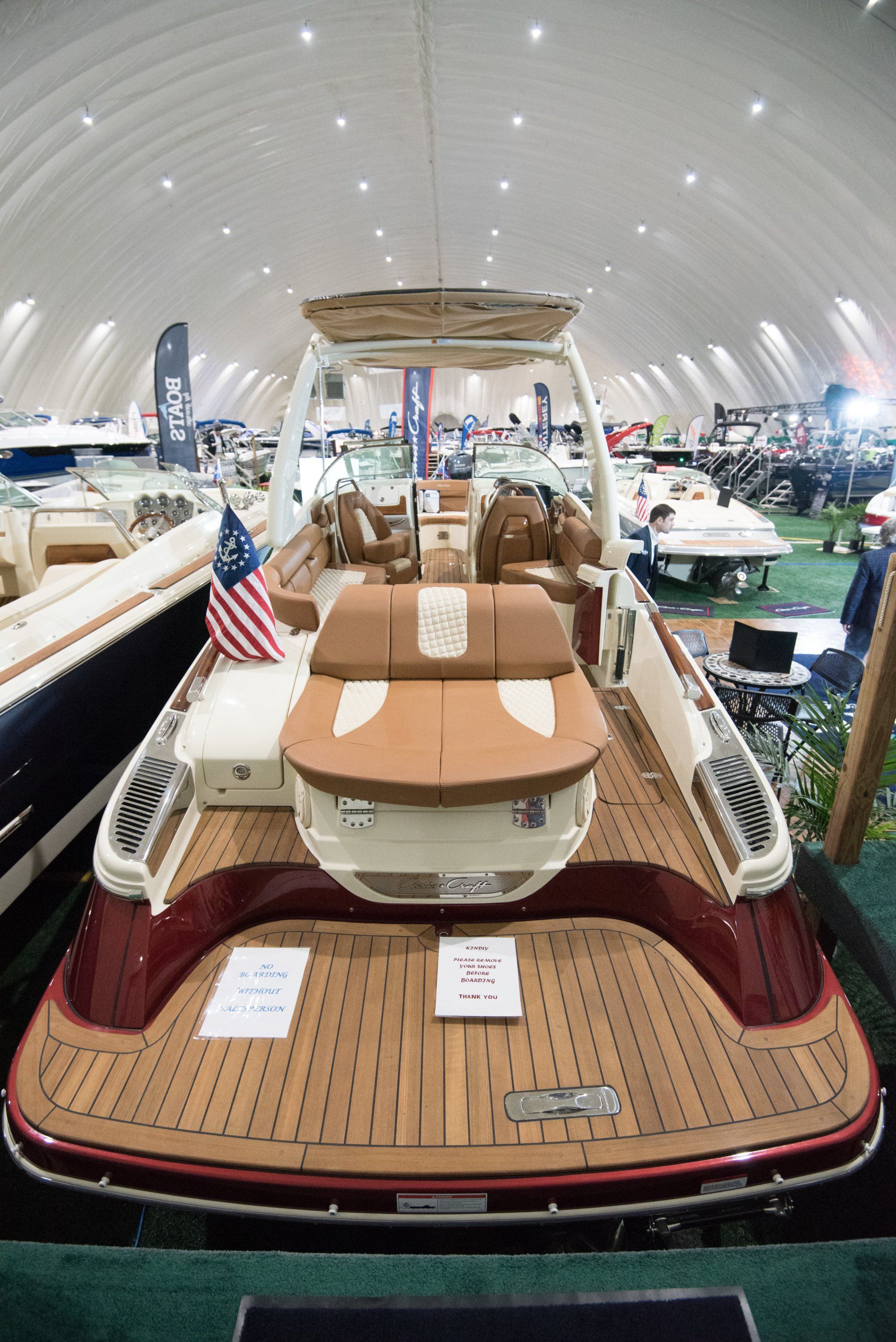 a boat with a wooden deck is sitting in a warehouse .