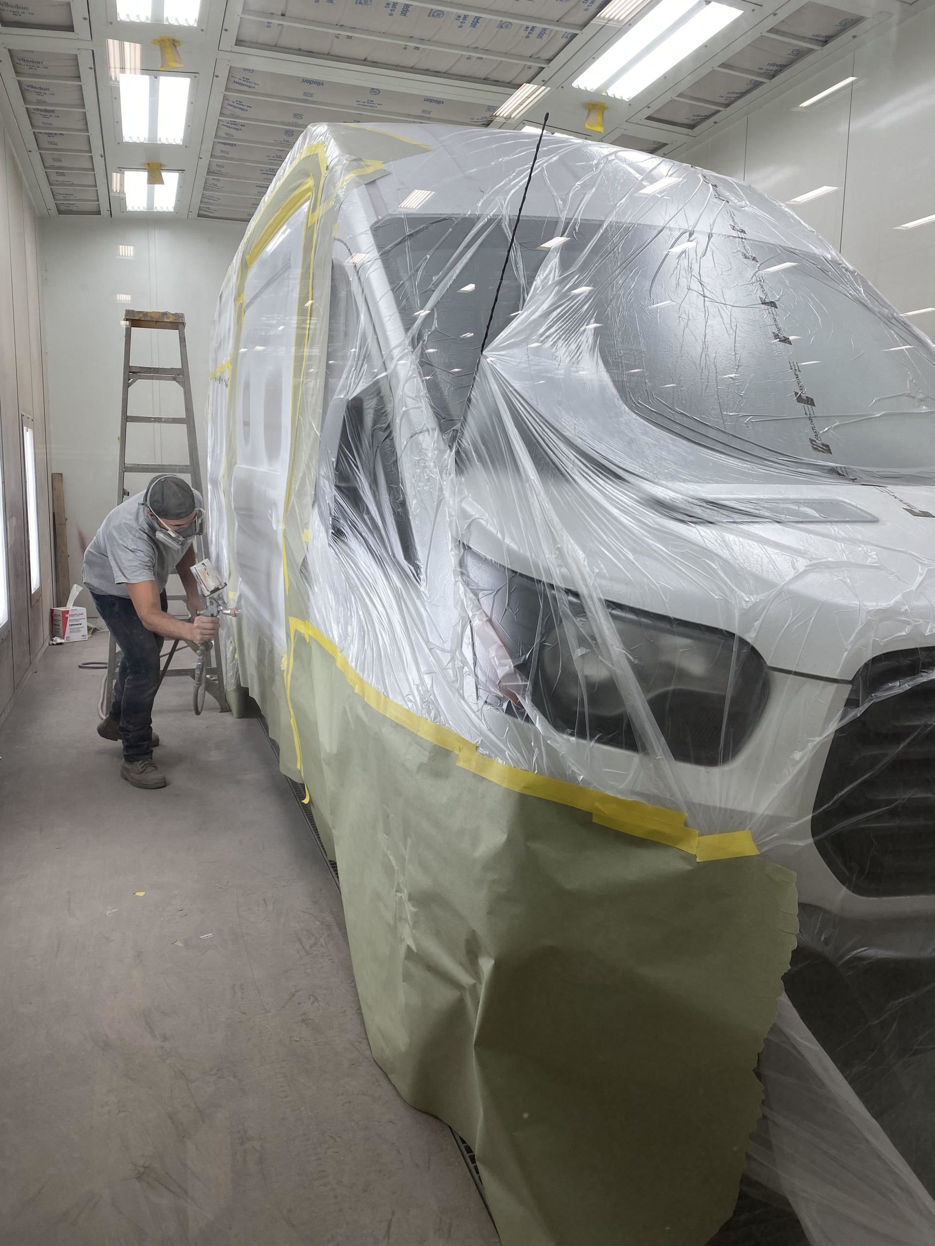experienced worker spray painting a truck
