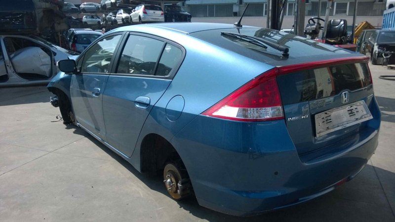 auto blu senza ruote in un centro ricambi