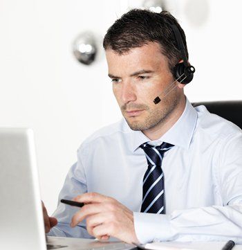 Handsome man using an headset in front of a laptop Handsome man using an headset in front of a laptop