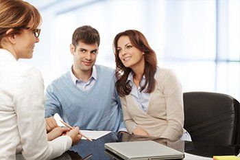 Young couple discussing financial plan with consultant — Emery & Costello in Leesburg, FL Young couple discussing financial plan with consultant — Emery & Costello in Leesburg, FL
