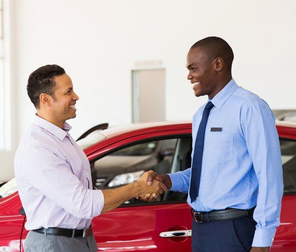 Vehicle Insurance — Shaking Hands in Car Showroom in Largo, MD Vehicle Insurance — Shaking Hands in Car Showroom in Largo, MD