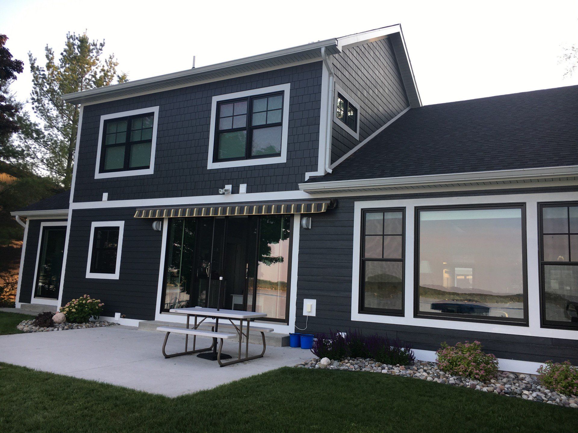 a black house with a picnic table in front of it