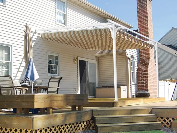 A white house with a wooden deck with a canopy over it