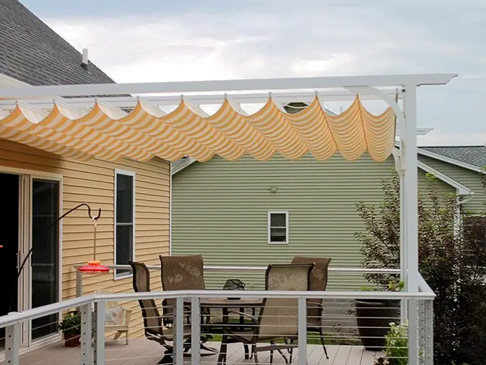 A deck with a table and chairs under a canopy