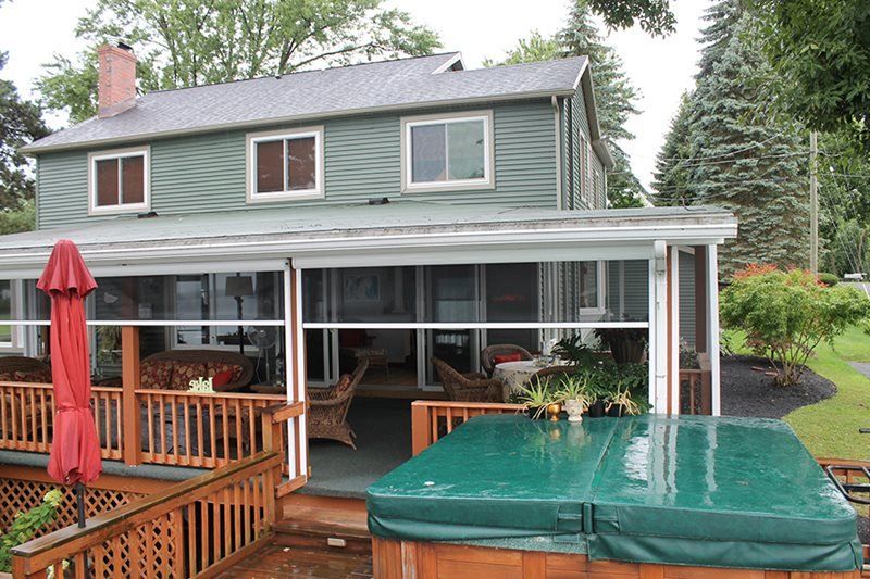 A house with a screened in porch and a hot tub