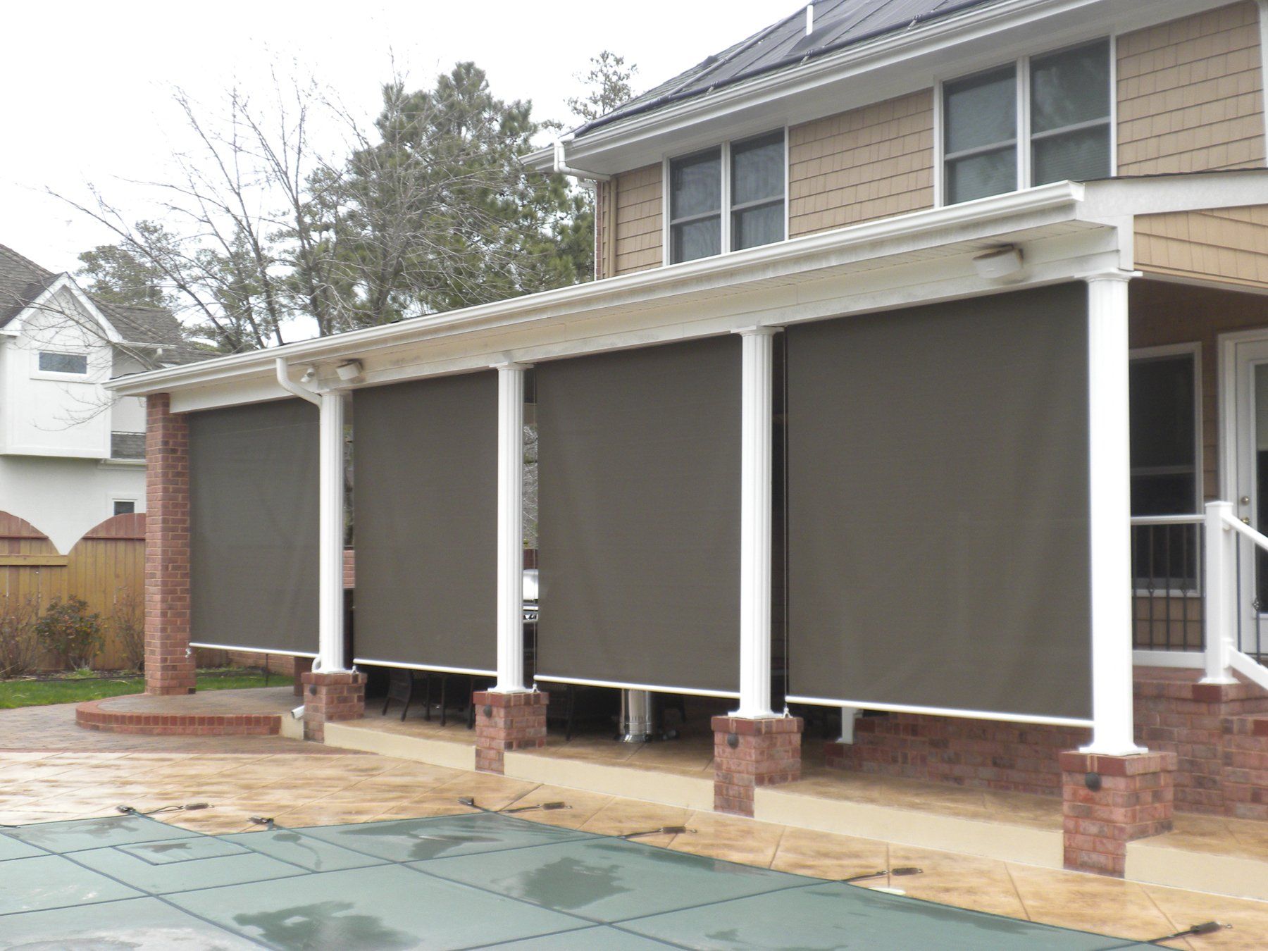 A house with a covered porch and a swimming pool