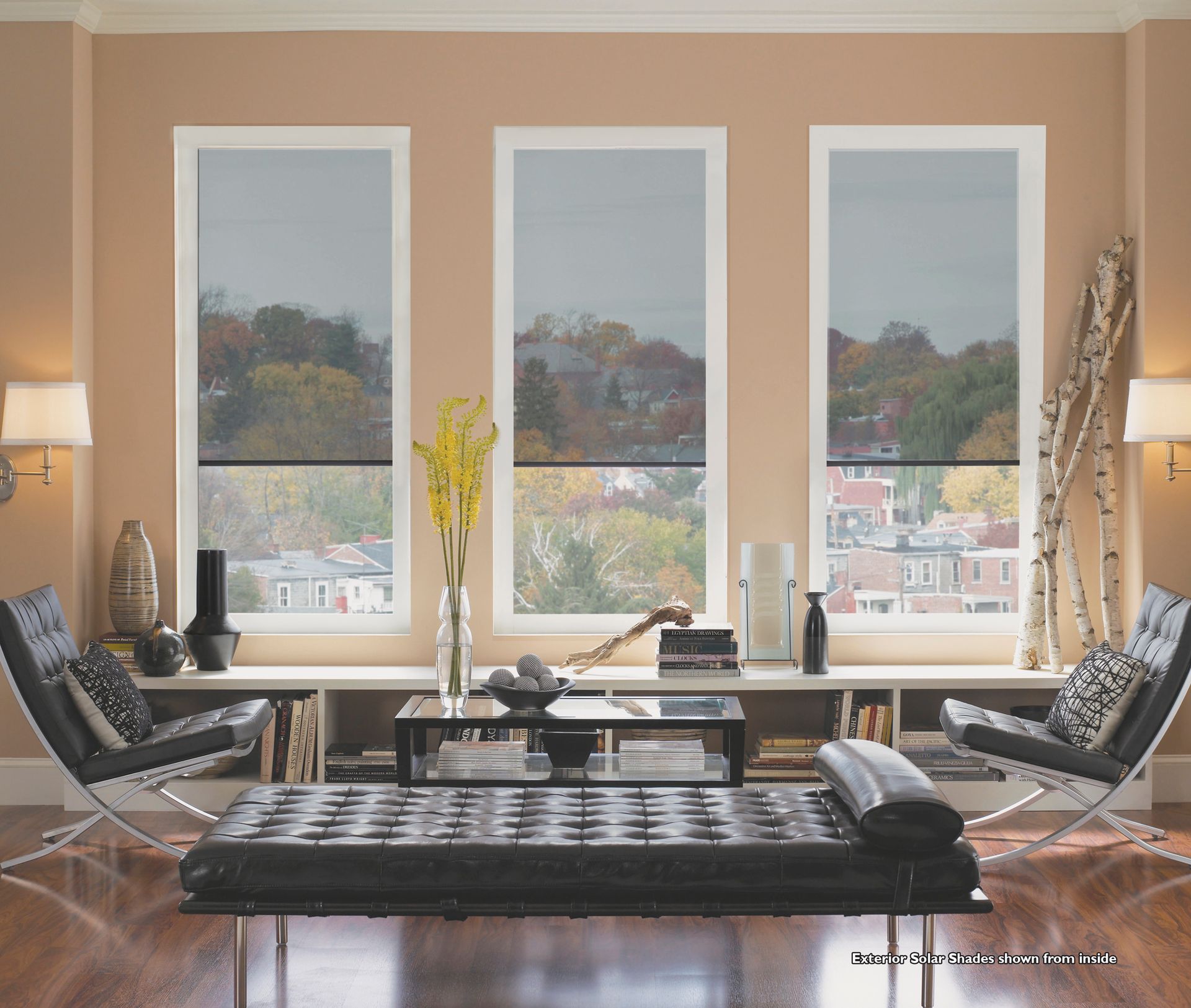 A living room with three windows and a bench