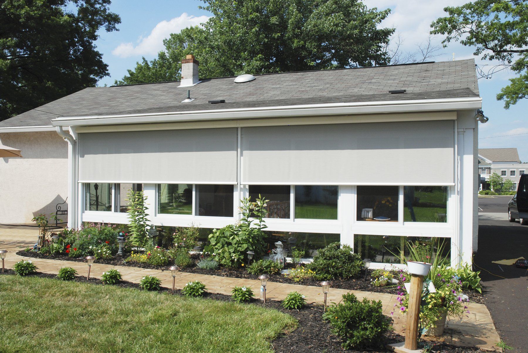 A white house with a gray roof and a lot of windows