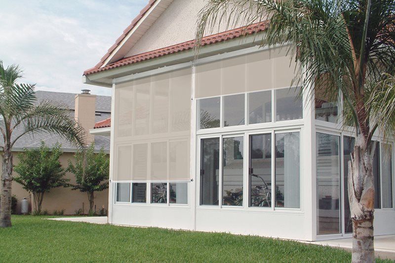 A house with a screened in porch and lots of windows