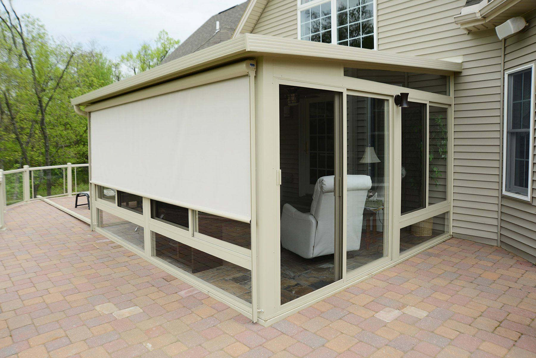 A house with a screened in porch with a white chair