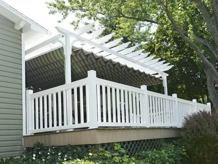 A white deck with a pergola on top of it