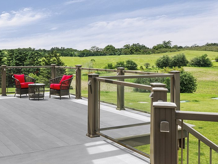 A deck with two red chairs and a table