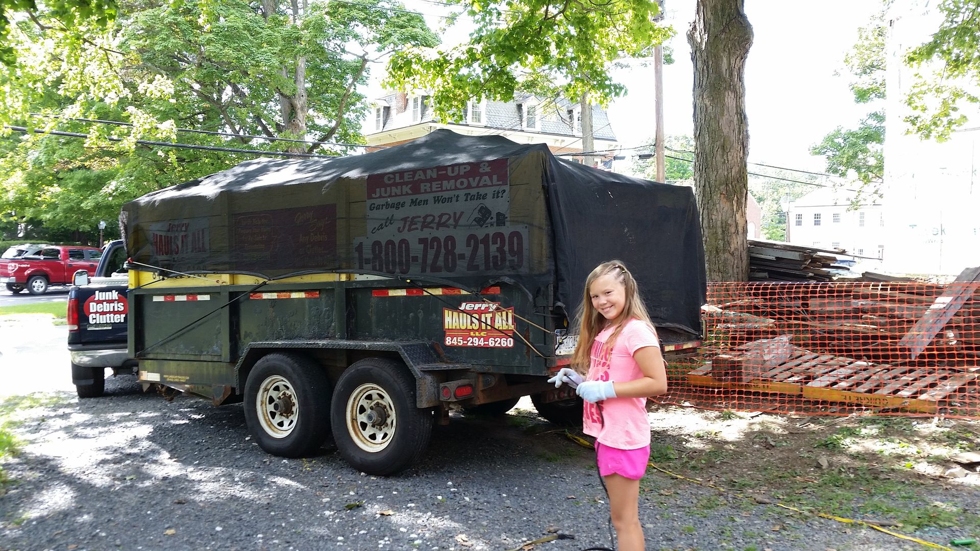 A little girl is standing in front of a trailer.