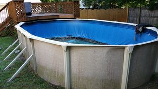 A large swimming pool with a blue cover on it