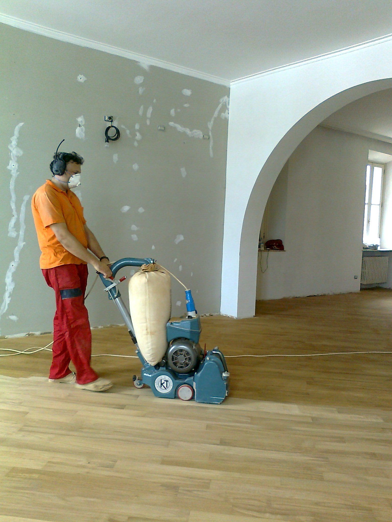 operaio con macchinario per lamatura mentre lavora sul pavimento di una casa