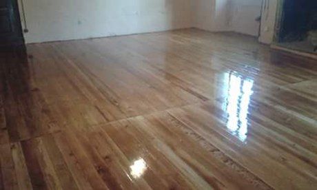 vista anolare di pavimento in legno con parete bianca