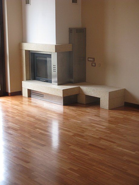 vista interna di una casa con pavimento in legno, camini e parete gialla