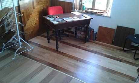vista interna di una casa con tavolo in legno con sedia rossa, finestra in vetro e pavimento in legno