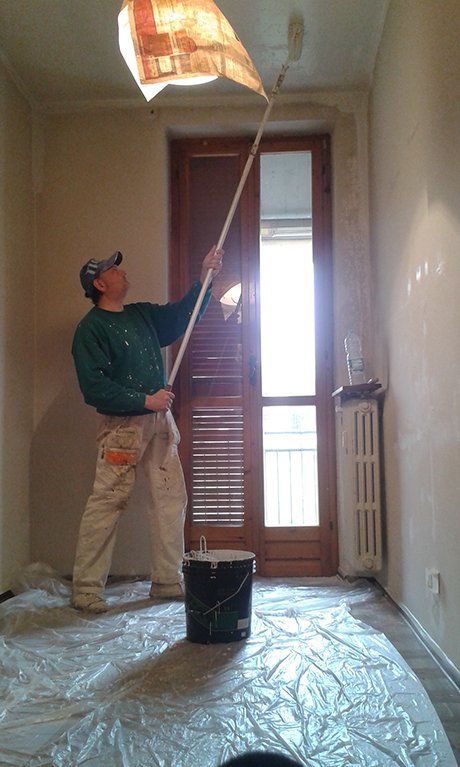 operaio mentre tintura di un soffitto di una stanza