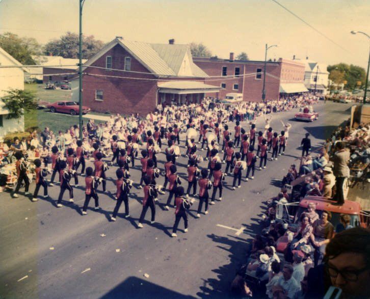 A marching band performing out around town.