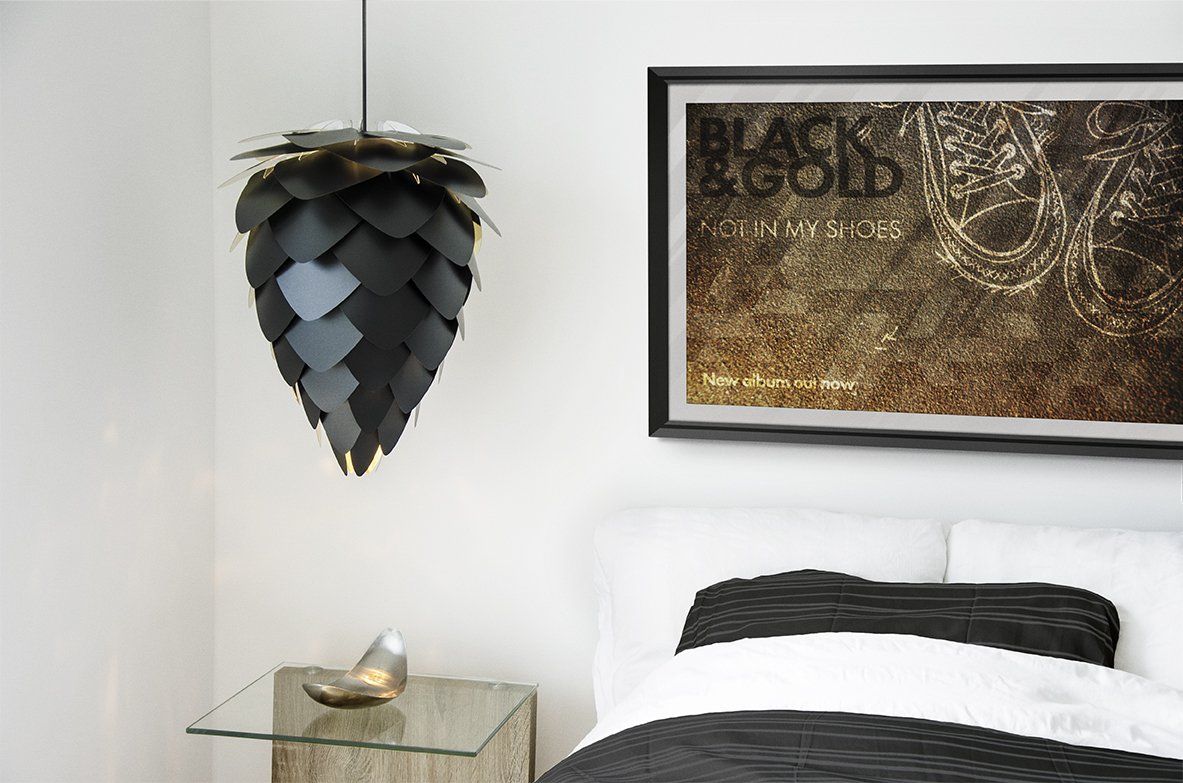 A bedroom with a bed , nightstand , lamp and a picture on the wall.