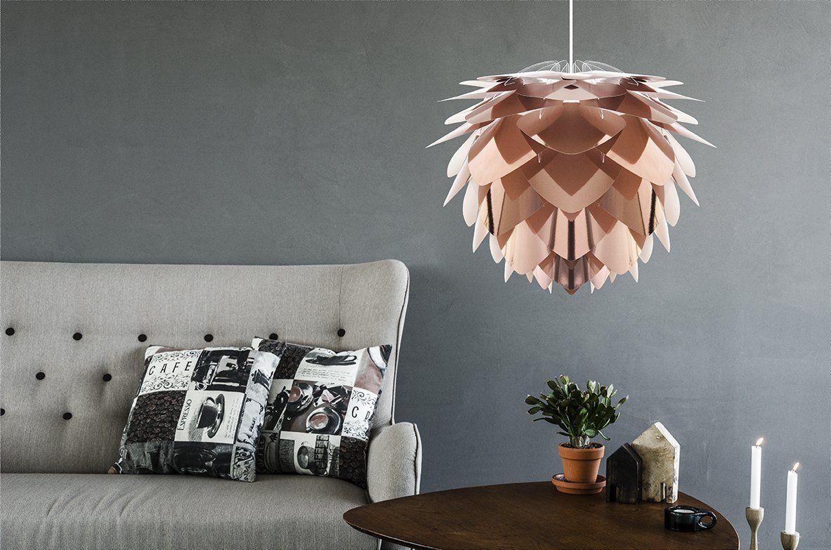 A living room with a couch a table and a lamp hanging from the ceiling