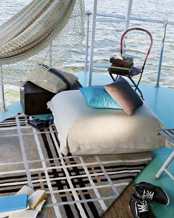 A hammock is hanging over a bed on a boat