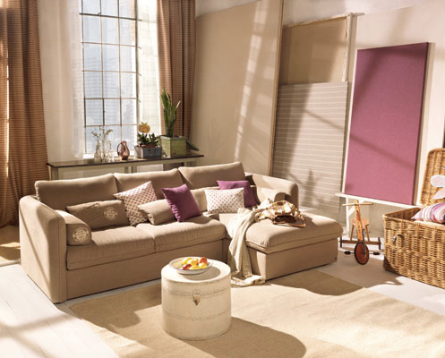 A living room with a large sectional couch and a round coffee table