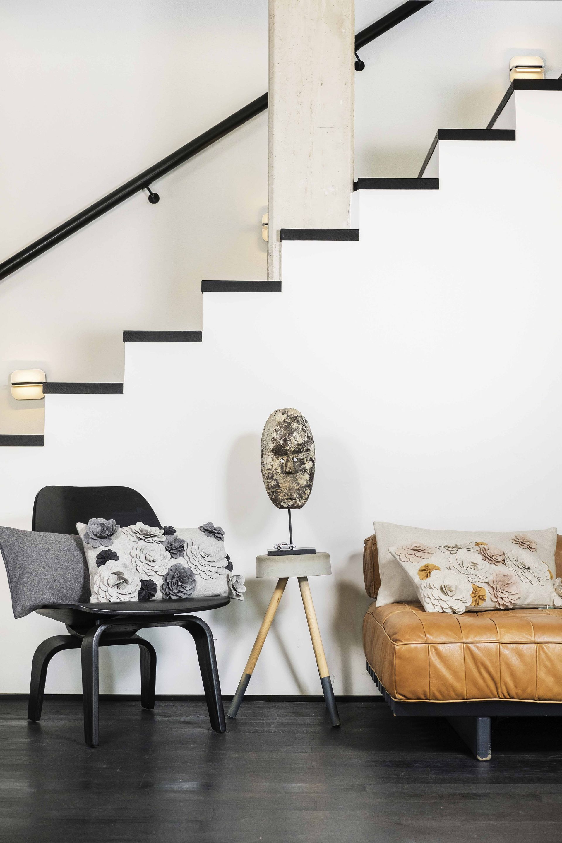 A living room with stairs and a couch and chair