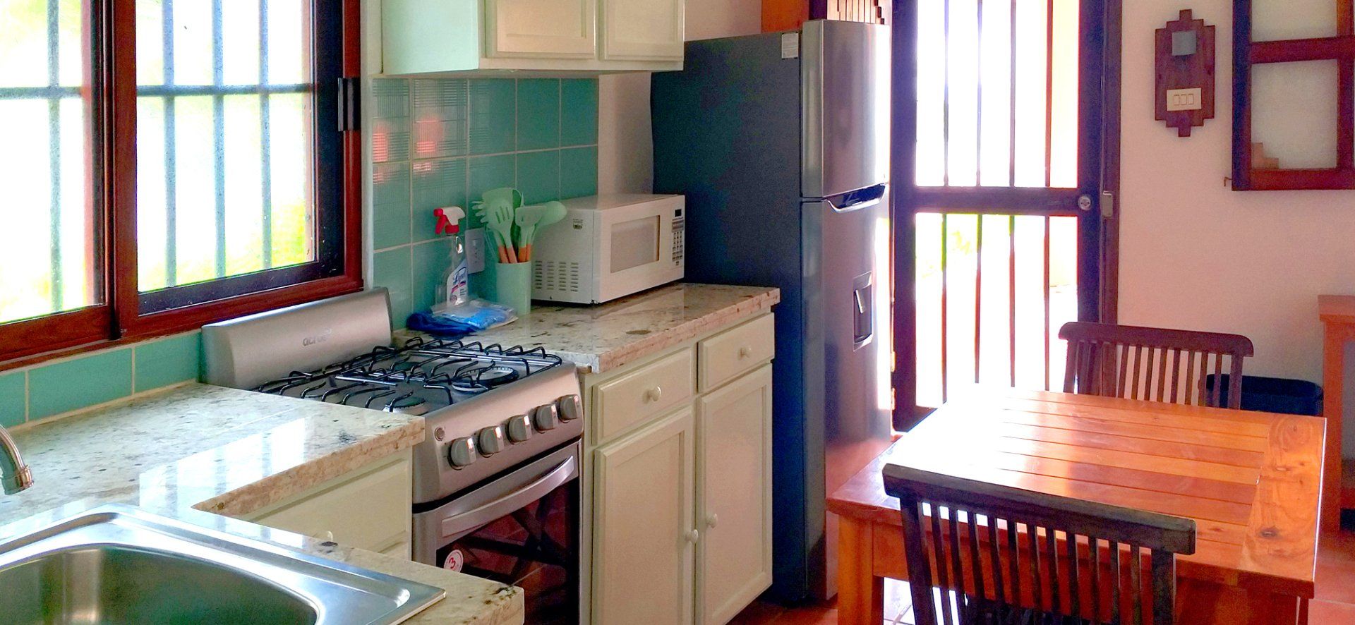 Beachfront Studio #1, Kitchen and table. Screened porch to patio