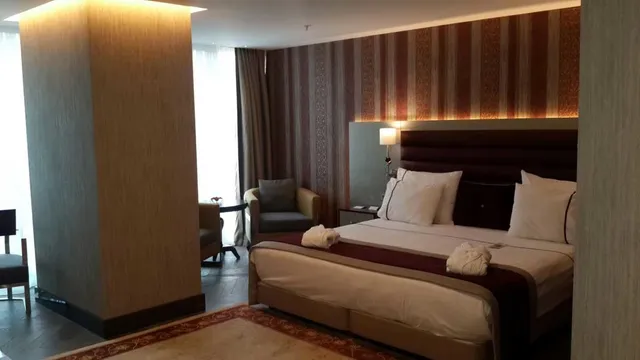 Kral yataklı ve sandalyeli bir otel odası.