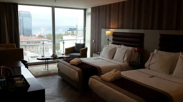Iki yataklı ve geniş pencereli bir otel odası