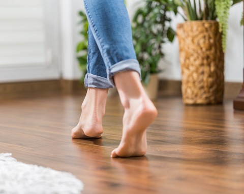 Floor heating. Young woman walking in the house on the warm floor. Gently walked the wooden panels.