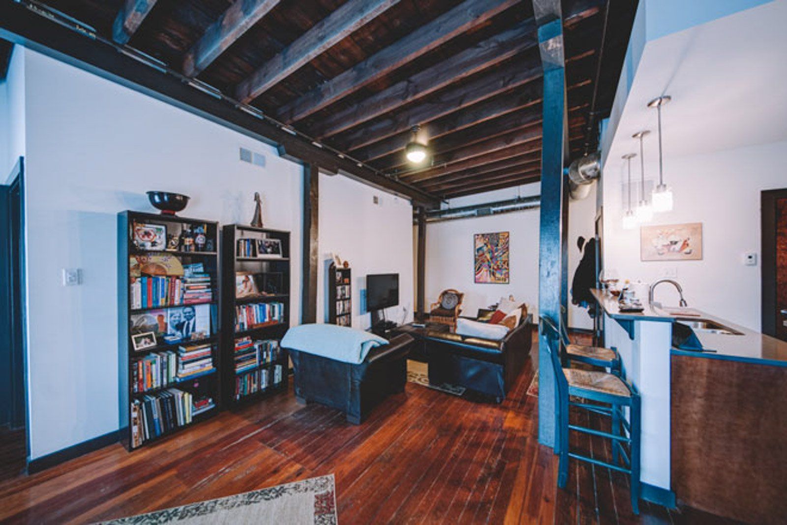 rustic furnished living room with stools, couches, book shelves