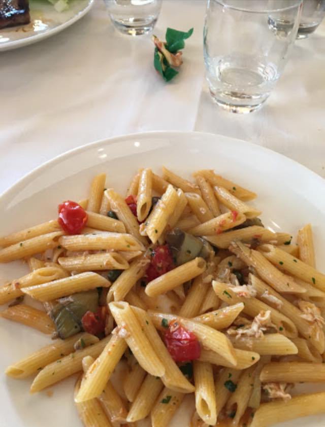 piatto di pasta corta con pesce e pomodorini