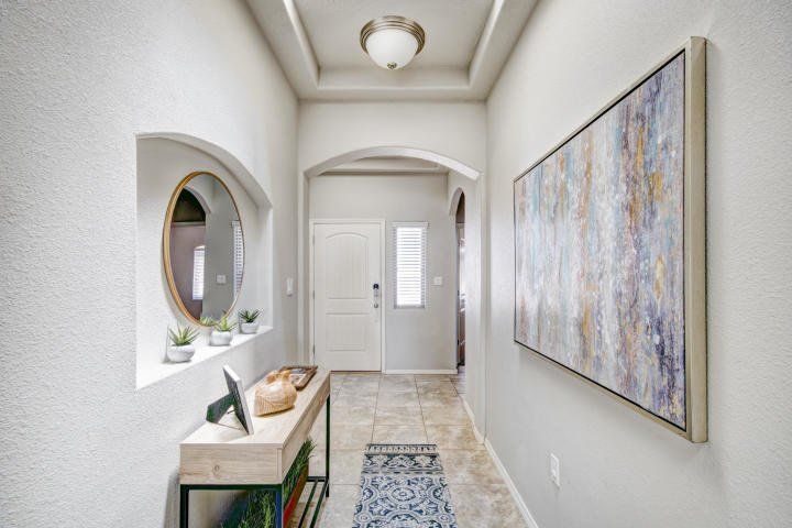 A hallway with a table and a painting on the wall.
