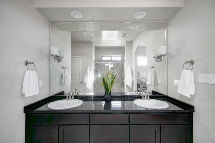 A bathroom with two sinks and a large mirror.