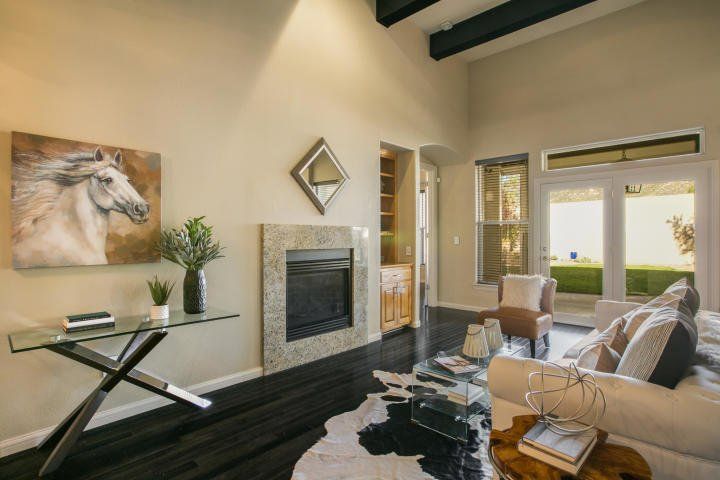 A living room with a fireplace and a painting of a horse on the wall
