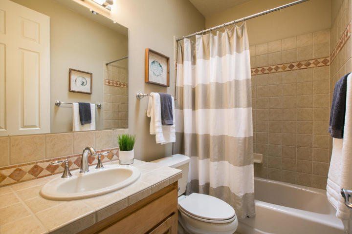 A bathroom with a sink , toilet , bathtub and shower curtain.