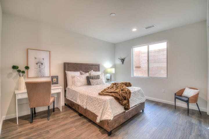 A bedroom with a bed , desk , chair and window.