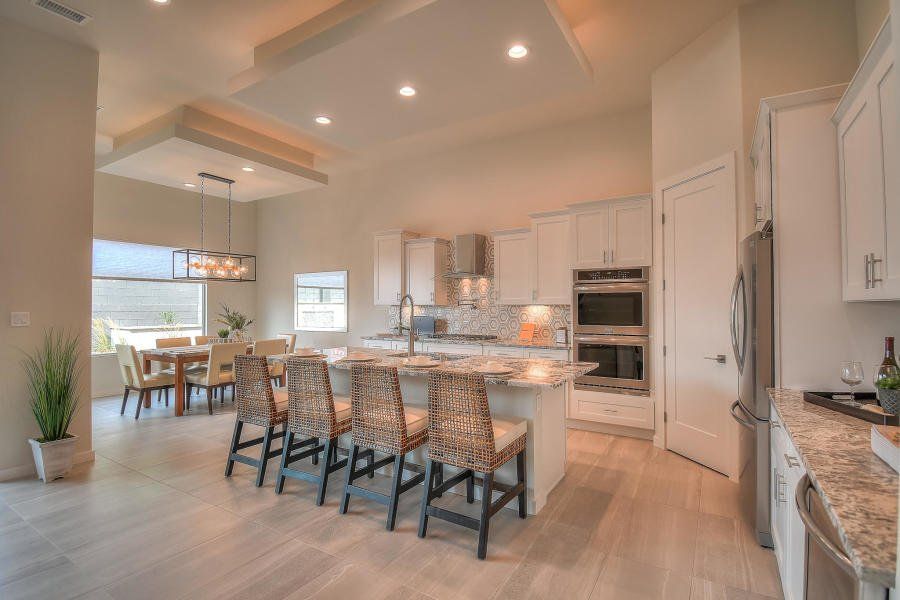 A kitchen with a large island and a dining room in the background.
