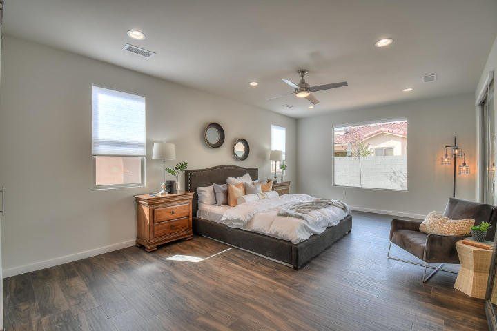 A bedroom with a bed , chair , nightstand , and ceiling fan.