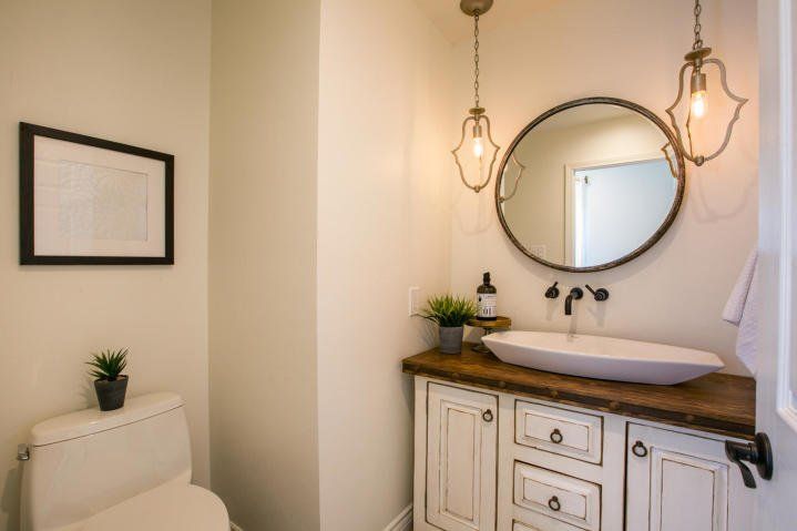 A bathroom with a toilet , sink and mirror.