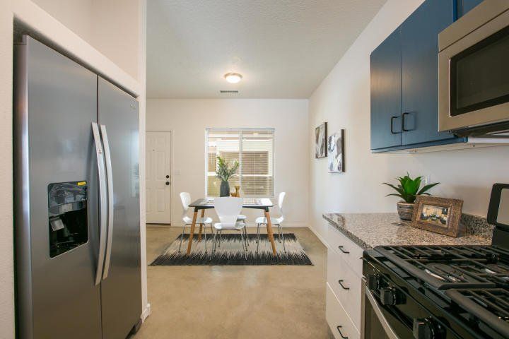 A kitchen with a stainless steel refrigerator , stove and microwave.